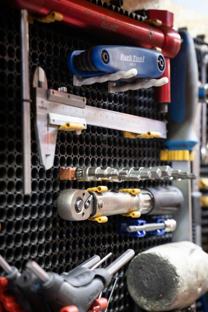 Workshop tools, including a calliper and torque tools, on a pegboard wall